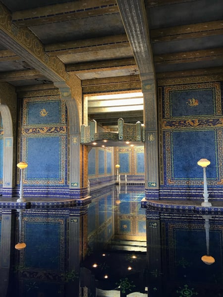 Ornate indoor pool with blue mosaic tiles, gilded architectural details, and classical columns at Hearst Castle. — Hearst Castle, Big Sur & the Highway 1 Coast