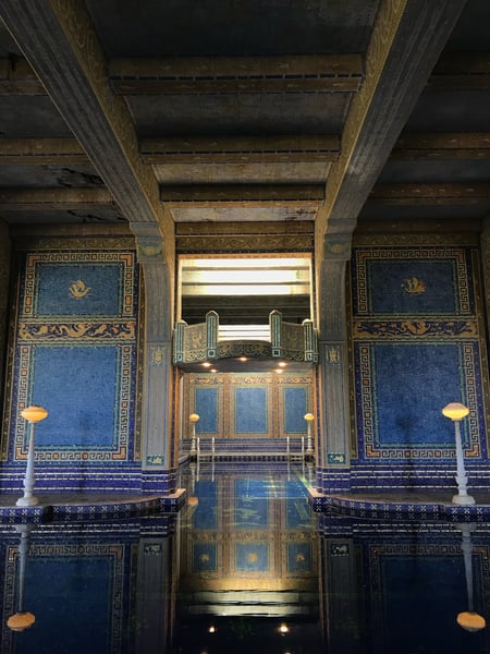 Ornate Roman-style indoor pool with blue mosaic tiles, gilded columns, and coffered ceiling at Hearst Castle. — Big Sur & the Highway 1 Coast