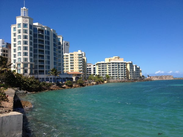 Beachfront resort buildings with clock tower overlooking turquoise waters at Fortín San Antonio, San Juan, Puerto Rico. — Viejo San Juan, San Juan