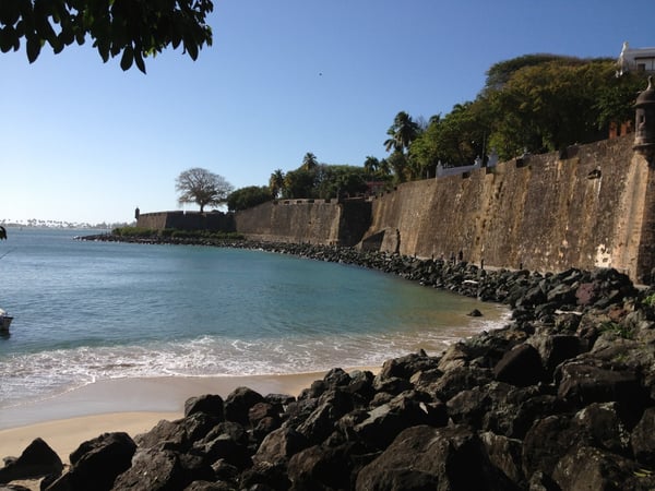 Historic stone fortification walls overlooking a turquoise bay beach in Old San Juan, Puerto Rico. — Plazuela de Isabel I de Castilla, San Juan