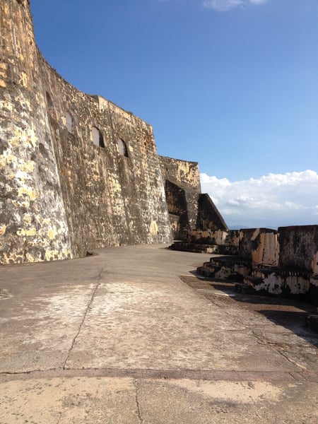 Castillo San Felipe del Morro's stone fortification walls and courtyard viewed from ground level under clear skies. — Castillo San Felipe del Morro, San Juan