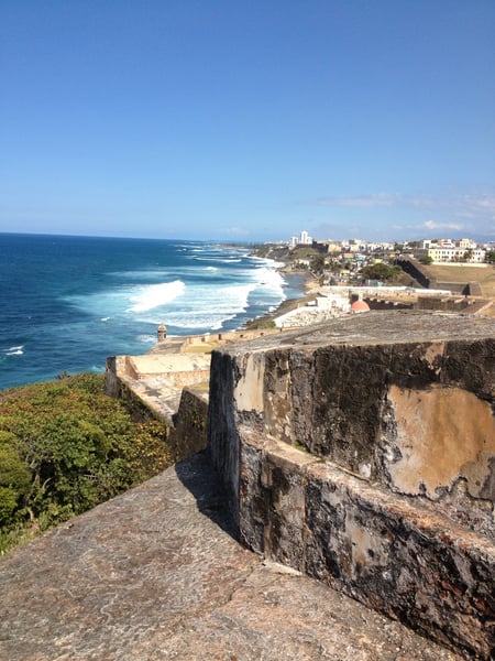 Historic fort ruins overlook a coastal shoreline with whitecapped waves and a hillside city in San Juan Antiguo, Puerto… — Viejo San Juan, San Juan