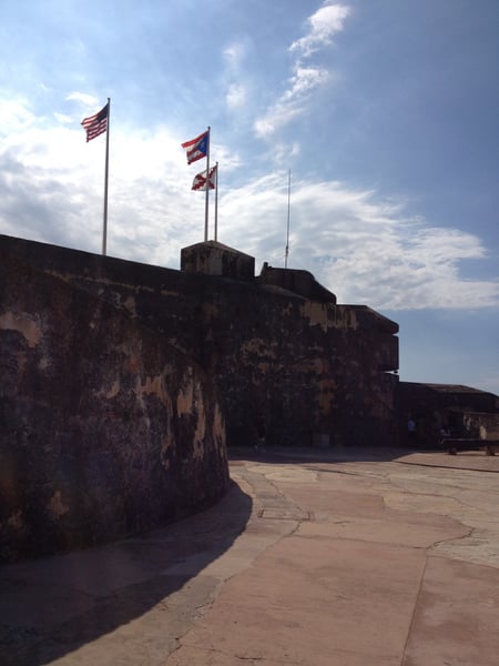 Fort San Felipe del Morro's weathered stone fortification with American and Puerto Rican flags flying from its ramparts. — Faro del Castillo San Felipe del Morro, San Juan