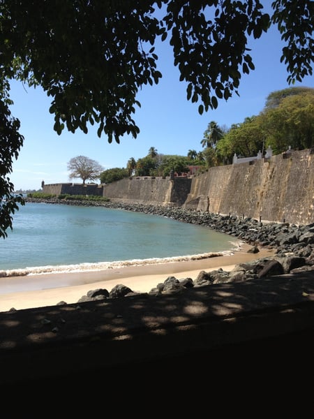 Historic stone fortification walls overlook a sandy beach and turquoise waters at P.º del Morro in San Juan, Puerto… — Viejo San Juan, San Juan
