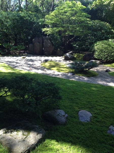 Japanese garden with manicured lawn, moss-covered stones, gravel paths, and lush tree canopy at the Japanese Tea Garden… — Golden Gate Park, San Francisco
