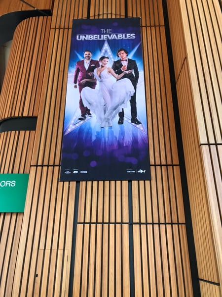 The Unbelievables promotional banner displayed on wooden slats at Sydney Opera House. — Sydney Opera House, Sydney