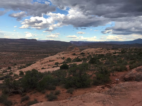 Red rock desert landscape with distant mesas viewed from a high vantage point near Moab, Utah. — Moab, Arches & Canyonlands