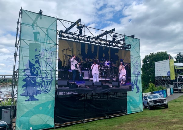 Live music performance on stage at an outdoor festival in South Hawthorne Waterfront Park, Portland, with performers in… — Downtown, Portland