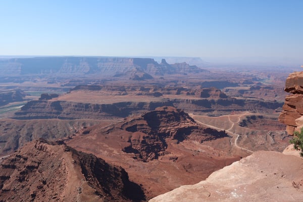 Expansive desert landscape with plateaus and mesas viewed from a high rocky outcrop in the Moab region. — Dead Horse Point State Park, Moab, Arches & Canyonlands