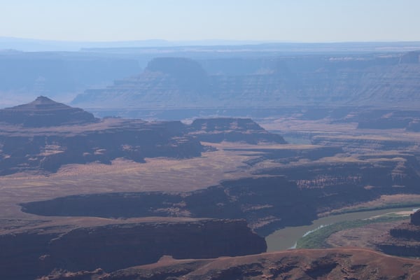 Aerial view of a vast desert plateau with layered mesas, buttes, and a winding river through arid terrain near Moab… — Dead Horse Point State Park, Moab, Arches & Canyonlands