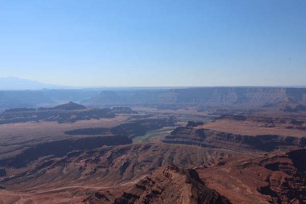Aerial view of the Canyonlands landscape near Moab, Utah, showing layered mesa formations, a meandering river, and vast… — Dead Horse Point State Park, Moab, Arches & Canyonlands