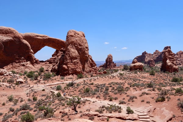 Landscape Arch and surrounding red rock formations in Castle Valley, Utah, viewed from the desert floor with hikers on… — Moab, Arches & Canyonlands