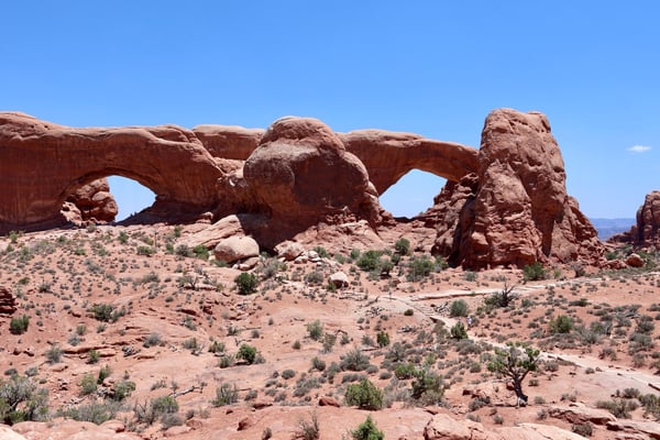 Massive natural sandstone arches in Castle Valley, Utah, viewed from the desert floor under clear skies. — Arches National Park, Moab, Arches & Canyonlands