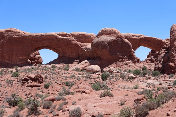 Natural rock arches in a desert landscape with sparse vegetation, viewed from the valley floor in Castle Valley, Utah. — Arches National Park, Moab, Arches & Canyonlands