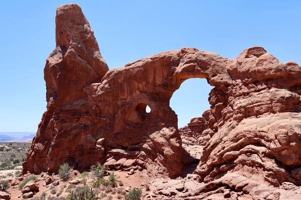 Distinctive red rock formation with natural arch in Castle Valley, Utah, viewed from ground level. — Arches National Park, Moab, Arches & Canyonlands