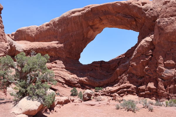 Natural sandstone arch formation at Primitive Loop Trailhead in Castle Valley, Utah, with desert vegetation and clear… — Moab, Arches & Canyonlands