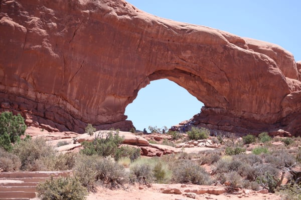 Natural stone arch in desert landscape with sparse vegetation viewed from ground level in Castle Valley, Utah. — Moab, Arches & Canyonlands