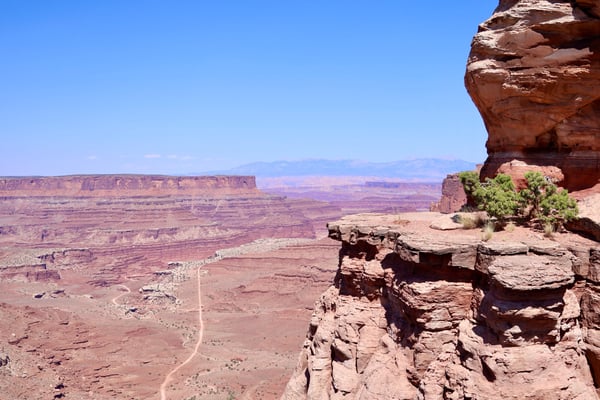Shafer Canyon Overlook offers a sweeping view of layered red rock formations and desert valley under clear blue sky. — Shafer Canyon Overlook, Moab, Arches & Canyonlands