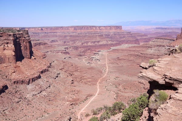 Shafer Canyon Overlook offers a vast view of layered red rock formations and a winding dirt road cutting through the… — Shafer Canyon Overlook, Moab, Arches & Canyonlands