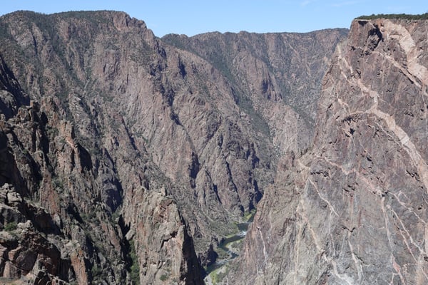 Painted Wall View showcases steep canyon walls with vertical columnar jointing framing a river valley below in northern… — Painted Wall View, Black Canyon of the Gunnison