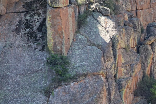 Weathered red and gray sandstone cliff face with layered geological formations at Painted Wall View in Montrose… — Painted Wall View, Black Canyon of the Gunnison
