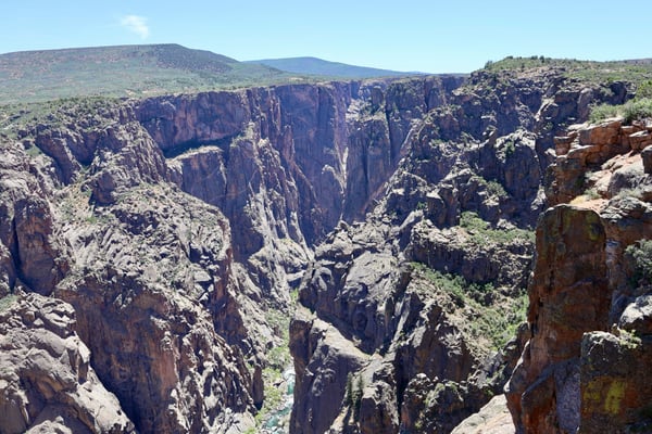 Deep rocky canyon with columnar basalt formations and a river visible in the valley below, viewed from Chasm View… — Chasm View, Black Canyon of the Gunnison