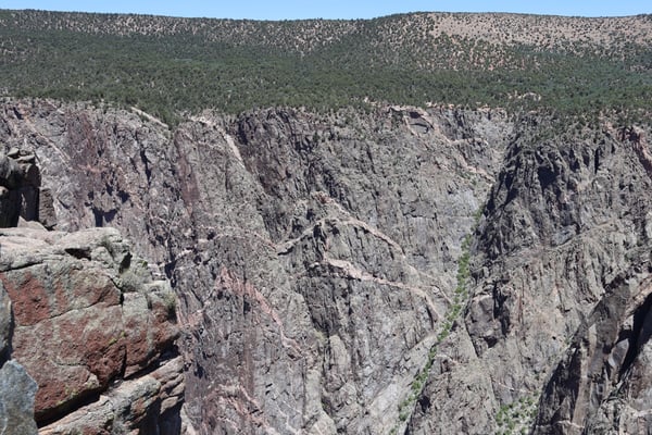 Deep rocky chasm with sheer granite walls and forested ridges viewed from Chasm View overlook in Colorado. — Chasm View, Black Canyon of the Gunnison