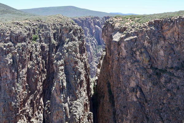 Deep rocky canyon with columnar basalt formations and vegetation-covered slopes visible at Rock Point near Montrose… — Rock Point, Black Canyon of the Gunnison