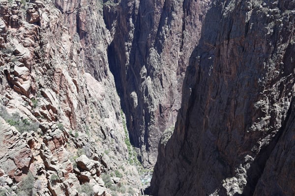Narrow rock canyon with vertical striations and sparse vegetation at Rock Point near Montrose, Colorado. — Rock Point, Black Canyon of the Gunnison