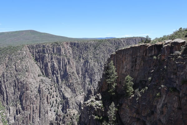 Dramatic columnar basalt cliffs and forested canyon at Gunnison Point, viewed from the South Rim in Colorado. — Gunnison Point, Black Canyon of the Gunnison