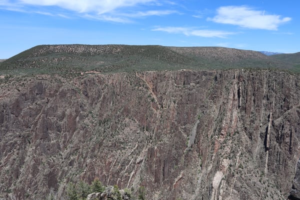 Deep canyon with dramatic columnar basalt formations and forested slopes viewed from Gunnison Point overlook. — Gunnison Point, Black Canyon of the Gunnison