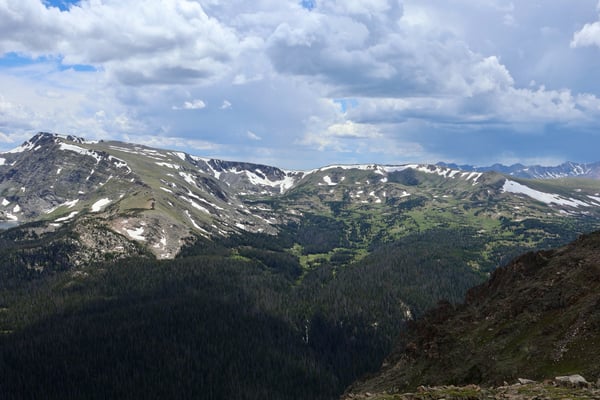 Alpine valley with coniferous forest and snow-patched peaks viewed from Tundra Communities Trailhead in summer. — Tundra Communities Trailhead, Rocky Mountain National Park