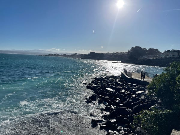Turquoise waters and rocky shoreline at Lovers Point Park in Pacific Grove, California, with residential buildings… — Big Sur & the Highway 1 Coast