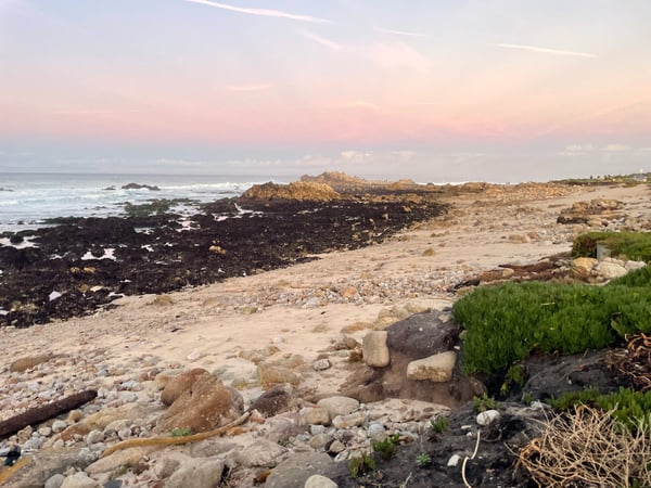 Rocky coastline with sandy beach and scattered boulders at Crespi Pond during golden hour sunset. — Pacific Grove Acres, Monterey & Carmel