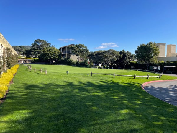 A manicured public park with open green lawn, wooden fencing, and surrounding trees under clear skies in Del Monte… — Big Sur & the Highway 1 Coast