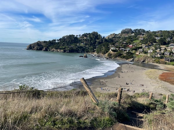 Sandy beach cove with gentle waves and hillside homes viewed from coastal bluff at Muir Beach, California. — Muir Beach, San Francisco