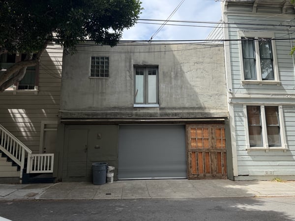 Row of residential townhouses with mixed architectural styles and weathered facades on a San Francisco street. — Western Addition, San Francisco