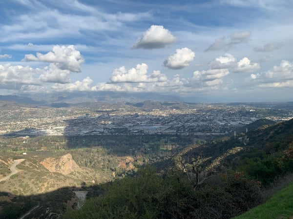 Expansive view of Los Angeles basin and surrounding mountains from a high vantage point in Griffith Park, with cumulus… — Griffith Park, Los Angeles