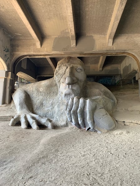 Large stone troll sculpture beneath a concrete bridge overpass in Fremont, Seattle. — Fremont Troll, Seattle