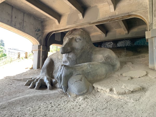 Large stone troll sculpture clutching a Volkswagen Beetle under a bridge in Fremont, Seattle. — Fremont Troll, Seattle