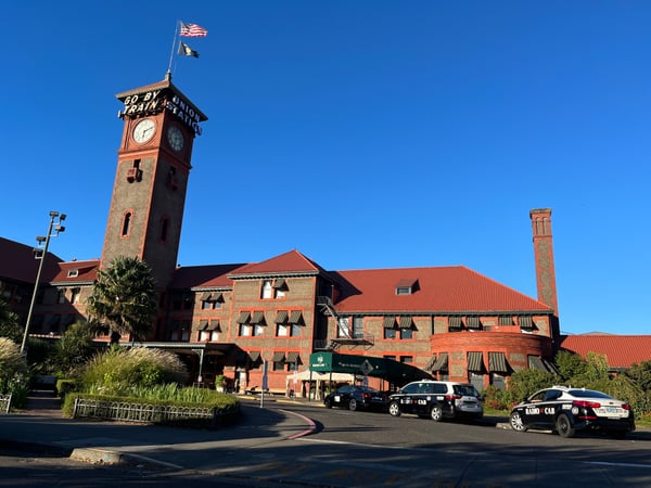 Historic brick Union Station building with clock tower and red roof, viewed from the street entrance with taxis parked… — Pearl District, Portland