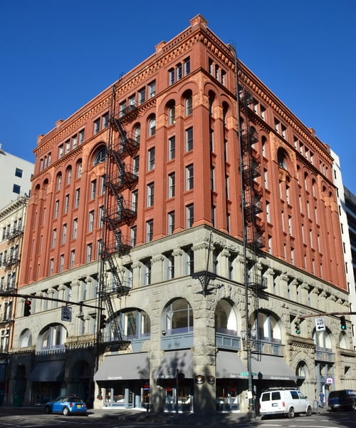 Dekum Building, a red-brick Romanesque Revival structure with ornate detailing and fire escapes, viewed from street… — Old Town, Portland