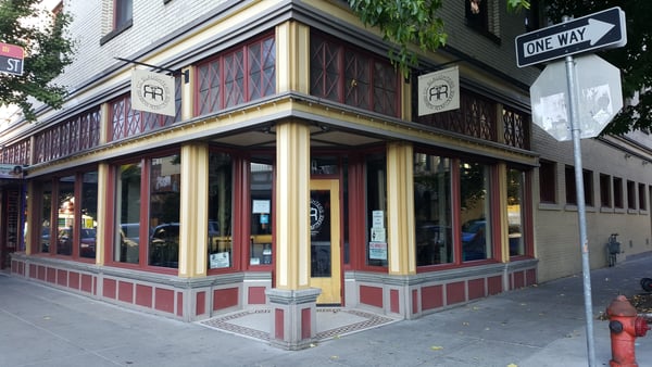 Historic corner storefront with red and cream Art Deco facade, ornamental railings, and street-level signage in an… — Old Town, Portland