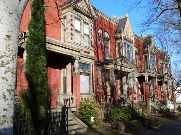 Row of Victorian-era red brick townhouses with ornate stone trim and mansard roofs in Portland, Oregon. — Northwest District, Portland