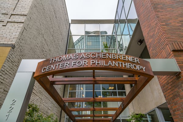 Entrance sign for the Thomas Aschenbrener Center for Philanthropy, a modern institutional building framed by brick… — Old Town, Portland