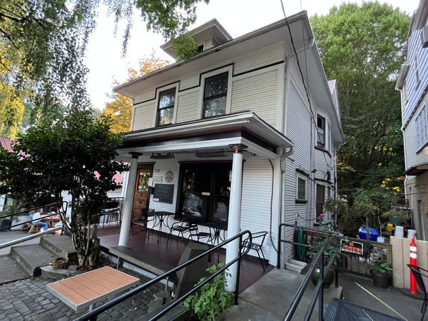 Historic two-story residential building with covered porch and storefront, surrounded by mature trees in a Portland… — Goose Hollow, Portland
