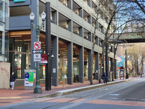 Downtown Portland street with modern mixed-use buildings, retail storefronts, and transit infrastructure on a winter… — Downtown, Portland
