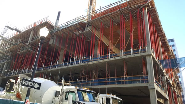 Multi-story building under construction with red steel framework and concrete floors in downtown Portland. — Goose Hollow, Portland
