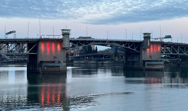 Morrison Bridge spanning the Willamette River at dusk with illuminated lift towers and Portland skyline in the… — Old Town, Portland