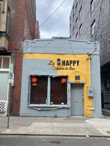 Le Happy Crêperie & Bar storefront with blue and yellow facade on a Portland street corner. — Northwest District, Portland